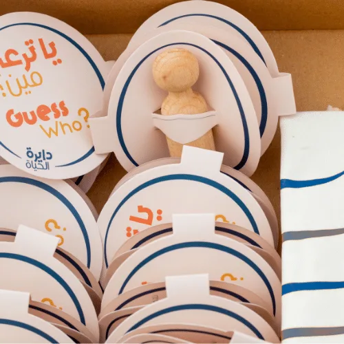 Close-up of the wooden Circle of Life characters and round question cards in the box